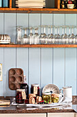 Shelf with jars and homemade preserves on worktop in rustic kitchen