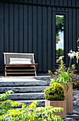 Stone steps, wooden bench on terrace and black façade