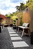 Linear gravel path with stone slabs in a modern garden