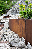 Garden bed with steel edging in rock garden