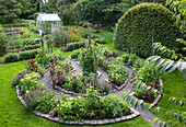 Round bed with herbs and vegetables in the spacious garden