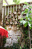 Wooden bird nesting boxes on a garden wall with ivy growth