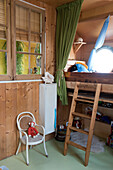 Children's room with half-height wooden loft bed and ladder