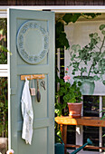 View of garden shed with green-painted door and plant picture