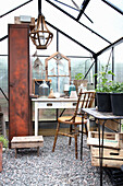 Table in the greenhouse with wooden chair and glass bottles