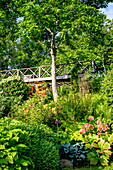 Lush garden with bridge and flowering plants in summer