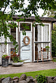 Cosy garden shed with decorated entrance and plants