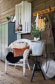 Rustic seating area with white rattan armchair and decorative elements