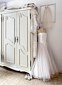 White wardrobe, wedding dress on a dressmaker's dummy and vintage decor in the bedroom