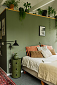 Bedroom with green wall, plants and carpet