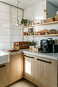 Modern kitchen with wooden cabinets, open shelf and coffee machine