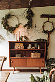 Vintage wooden shelf with Christmas decorations and homemade wreaths