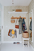 Entrance area with patterned wallpaper, wooden hook moulding and mirror