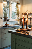 Cosy kitchen with candles, concrete worktop and green cupboards