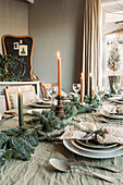 Festive table setting with green fir branches and candles