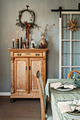 Country-style dining room with vintage chest of drawers and candle decorations