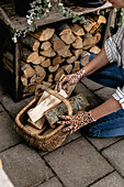 Basket with firewood in front of wood store on stone terrace