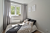 Modern bedroom with grey curtains and pictures on the wall