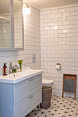 Bathroom with white metro tiles, patterned tiled floor and vintage washboard