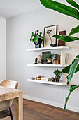 Floating shelves with minimalist decorations and plants in the dining area