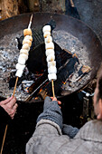 Roasting marshmallows on a spit over an open fire