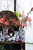 White and blue porcelain vases with autumn flowers and decorative Christmas baubles
