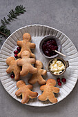 Plate with biscuit men, cranberry jam and butter