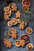 Gingerbread men and dried citrus slices on a metal tray