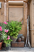 An der Wand befestigte Kraftpapierrolle, blühender Oleander und Pflanzen