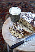Raisin cake with icing sugar and cream on a wooden table