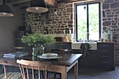 Country-style kitchen with natural stone wall and wooden furniture