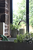 Kitchen with stone wall and sink with meadow flowers