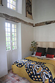 Bedroom with rustic wooden beams and patterned bedspread