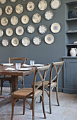 Dining room with wooden table and chairs and wall decoration made of plates