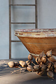 Ceramic bowl and dried flowers, wooden ladder in the background