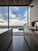 Modern kitchen with panoramic windows and views of the pool and ocean