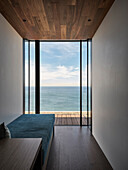 Sea view through floor-to-ceiling windows, wooden floor and ceiling