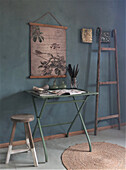 Vintage-Tisch mit botanischem Druck an blauer Wand