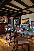 Festively laid dining table with wooden furniture and atmospheric lighting in a rustic dining room
