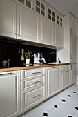 Bright fitted kitchen with black tiles and wooden worktop