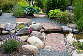 Kiesweg mit Natursteinen im sommerlichen Garten