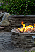 Round stone fireplace in the garden with surrounding nature