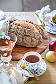 Freshly baked bread on a wooden table with tea and apples
