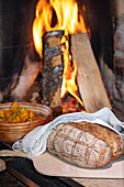 Home-baked bread with artistic patterns in front of a fireplace