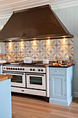 Country-style kitchen with tiled splashback and vintage cooker
