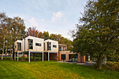 Contemporary pile dwelling with timber elements, garden view