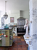 Country house kitchen with terracotta floor and angel figurine