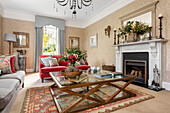 Classic living room with fireplace, glass table and red velvet sofa
