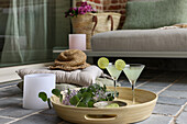 Cozy terrace with tray, cocktails and decorative cushions