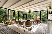 Dining area with a view of the sunny garden through panoramic windows